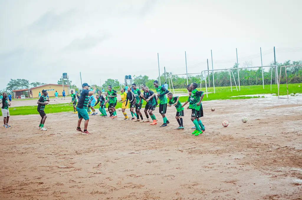 Children training together on an open community pitch